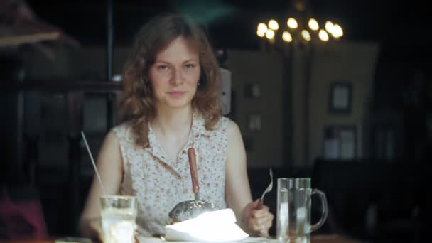 Mujer joven comiendo comida rápida, hamburguesa negra — Vídeos de Stock