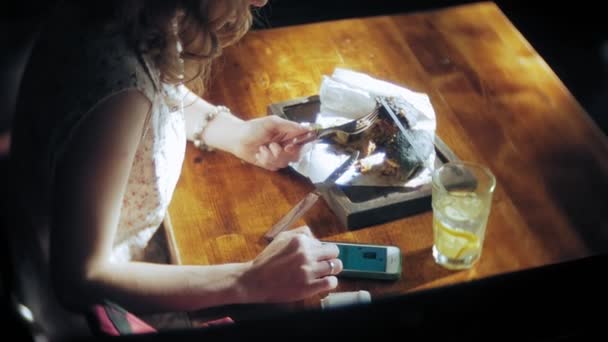 Mujer joven comiendo comida rápida, hamburguesa negra — Vídeos de Stock