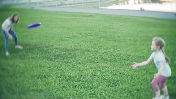 Lycklig kvinna och dotter spelar i frisbee i park — Stockvideo