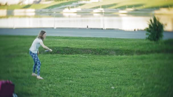 Mulher feliz e filha jogando no frisbee no parque — Vídeo de Stock