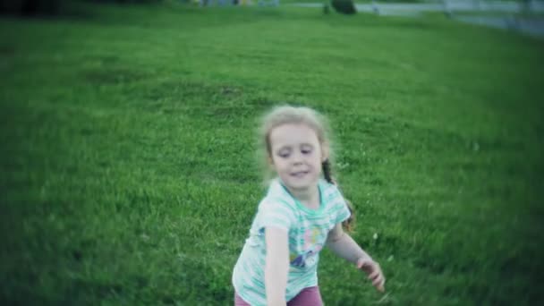 femme heureuse et fille jouer dans frisbee dans le parc 