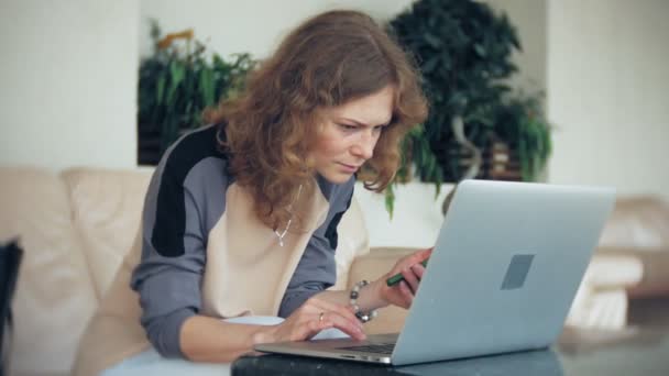 Молодая красивая деловая женщина сидит на диване за столом с планшетом — стоковое видео