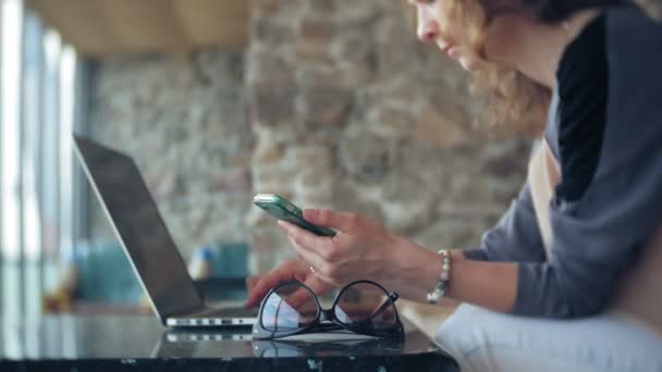 Joven mujer de negocios hermosa sentado en el sofá en la mesa con la tableta — Vídeos de Stock