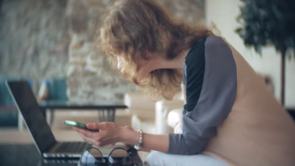 Joven mujer de negocios hermosa sentado en el sofá en la mesa con la tableta — Vídeos de Stock