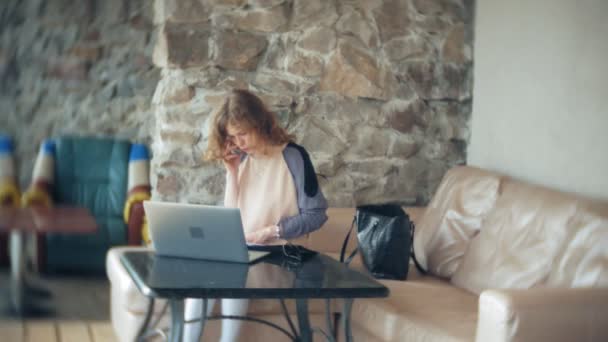 Young beautiful business woman sitting on sofa at table with tablet — Stock Video