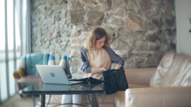 Joven mujer de negocios hermosa sentado en el sofá en la mesa con la tableta — Vídeos de Stock