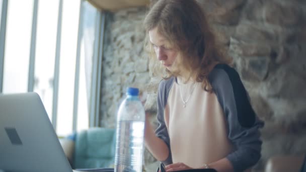 Divan tablet ile masada oturan genç güzel iş kadın — Stok video