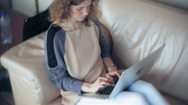 Divan tablet ile masada oturan genç güzel iş kadın