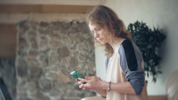 Joven mujer de negocios hermosa sentado en el sofá en la mesa con la tableta y el uso de teléfono inteligente — Vídeos de Stock