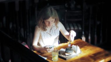 Genç kadın yemek lokanta, siyah hamburger