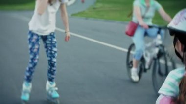 Annesi kızının paten parkta kaymayı yardımcı olur.