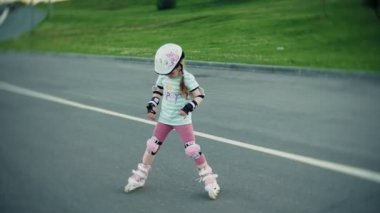 Annesi kızının paten parkta kaymayı yardımcı olur.