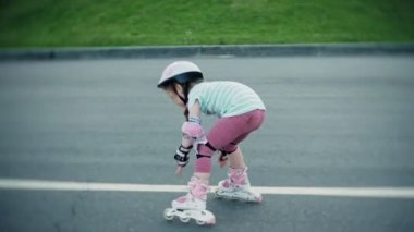 Annesi kızının paten parkta kaymayı yardımcı olur.