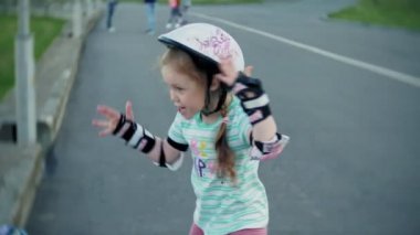 Annesi kızının paten parkta kaymayı yardımcı olur.