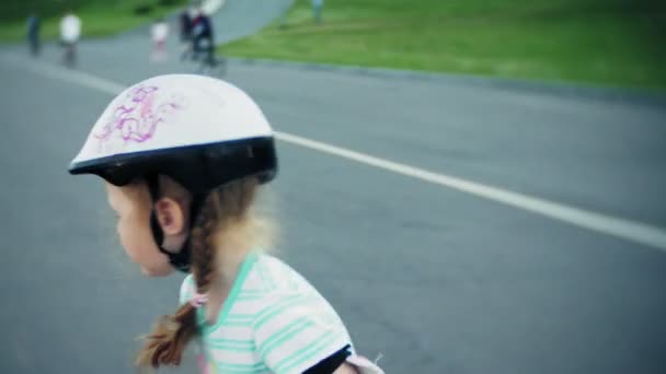Moeder helpt haar dochter om te skaten in een rolschaatsende park — Stockvideo