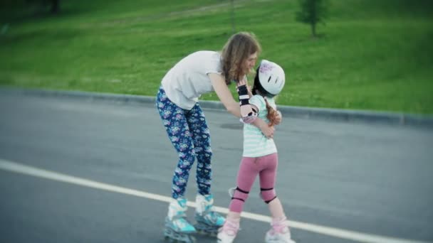 Матері допомагає її дочка кататися в roller-skating парку — стокове відео