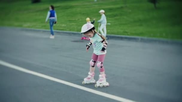 Madre ayuda a su hija a patinar en un parque de patinaje — Vídeos de Stock