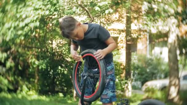 El niño lava su bicicleta BMX con agua y espuma — Vídeo de stock