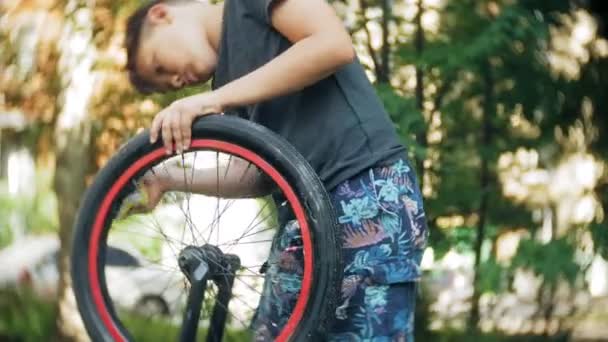 El niño lava su bicicleta BMX con agua y espuma — Vídeo de stock