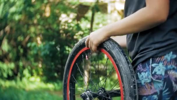 Мальчик моет свой велосипед BMX водой и пеной — стоковое видео