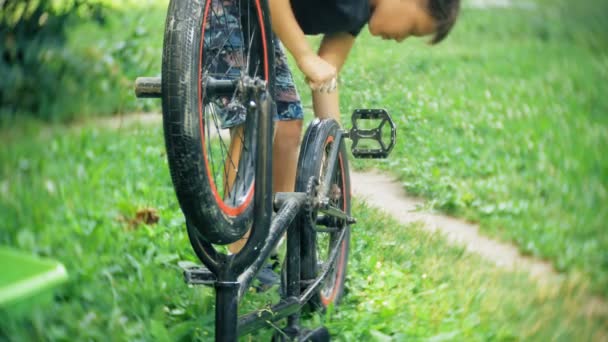 The boy washes his BMX bicycle with water and foam — Stock Video