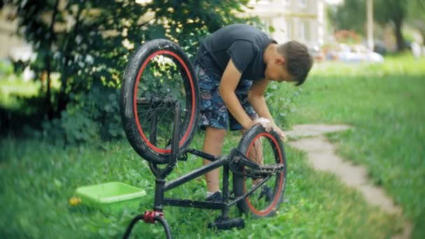 Il ragazzo lava la sua bicicletta BMX con acqua e schiuma — Video Stock