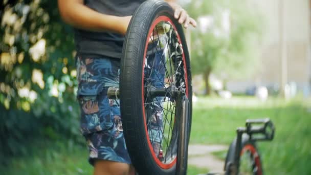 El niño lava su bicicleta BMX con agua y espuma — Vídeo de stock