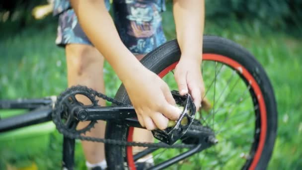 El niño lava su bicicleta BMX con agua y espuma — Vídeo de stock