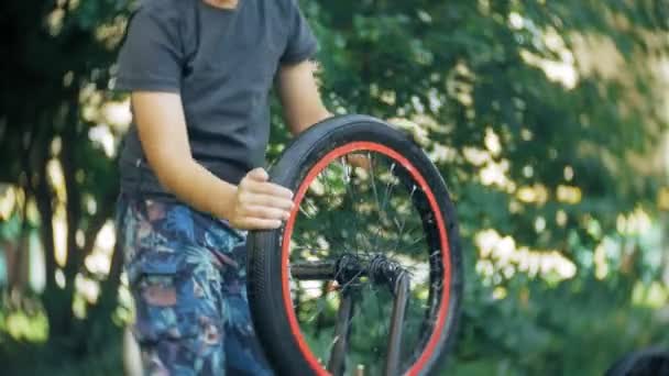 O menino lava sua bicicleta BMX com água e espuma — Vídeo de Stock