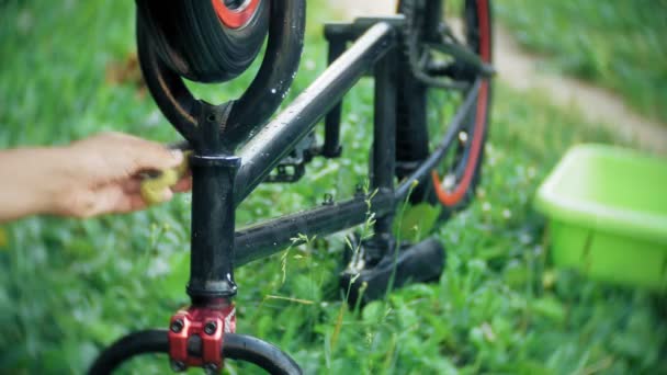 Der Junge wäscht sein Fahrrad mit Wasser und Schaum — Stockvideo