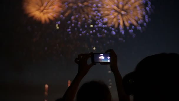 Espectadores con smartphones. Fotografía fuegos artificiales en el teléfono, manos de cerca — Vídeos de Stock