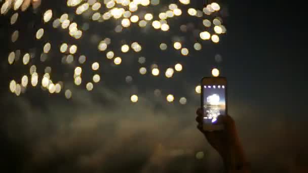 Espectadores con smartphones. Fotografía fuegos artificiales en el teléfono, manos de cerca — Vídeos de Stock