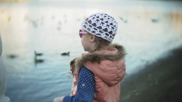 白鳥の湖で餌若い女性と冬の鳥に餌をアヒル — ストック動画