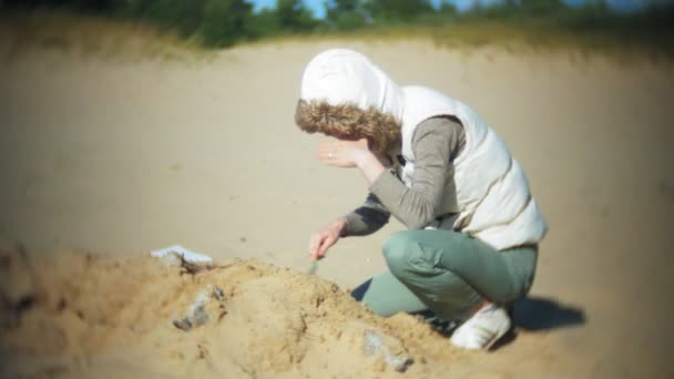 De vrouw is betrokken bij graafwerkzaamheden botten in het zand, het skelet en de archeologische tools. — Stockvideo