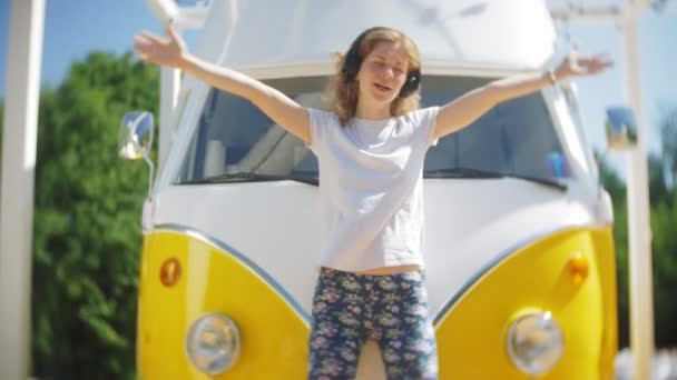 Mujer joven al aire libre por vagón amarillo coche escuchar música en los auriculares con el teléfono inteligente - relajarse, disfrutar, concepto de la tecnología y viajar — Vídeos de Stock