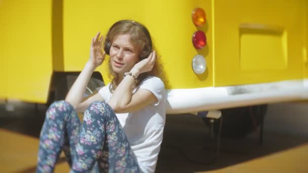 Jeune femme en plein air par voiture de vagon jaune écouter de la musique dans les écouteurs à l'aide d'un smartphone relaxant, profiter, concept de technologie et Voyage — Video