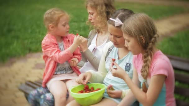 Śmieszne dzieci dziewczynka jedzenie truskawek w parku — Wideo stockowe