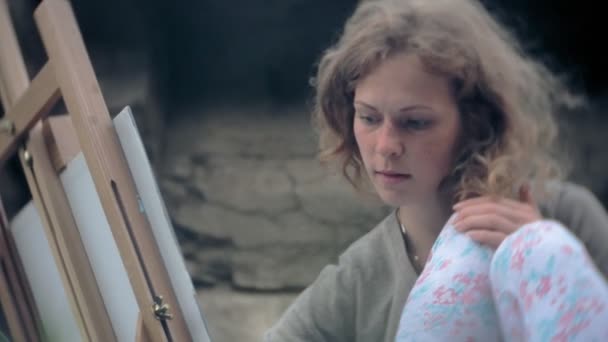 Ung kvinna bygger på staffli målarfärg och pensel gamla vintage bridge — Stockvideo