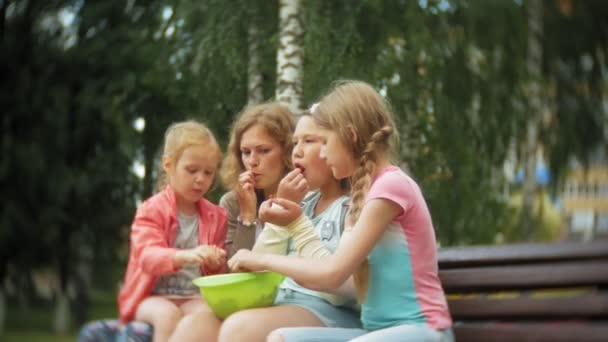 Смешные дети едят клубнику в парке — стоковое видео