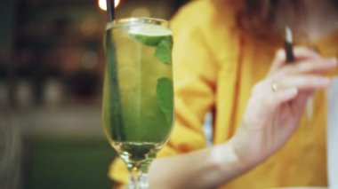 Genç kadın bir kafe barda bir kokteyl içer