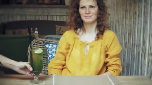 Genç kadın bir kafe barda bir kokteyl içer — Stok video