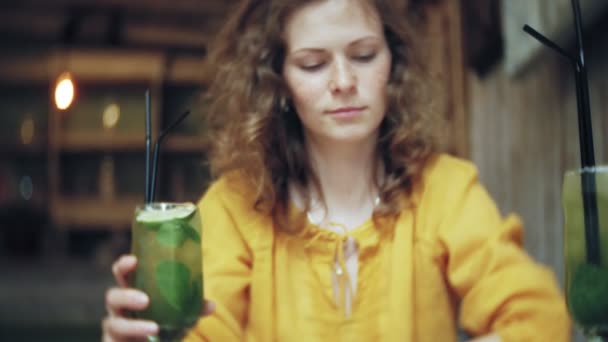 젊은 여자는 카페 바에서 칵테일 음료 — 비디오