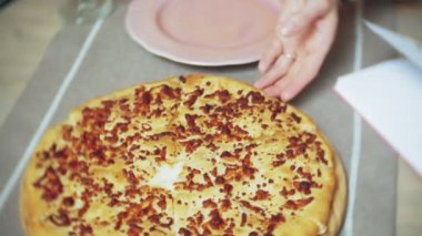 Genç bir kadın bir kafe barda bir pasta yiyor ve bir telefon kullanır