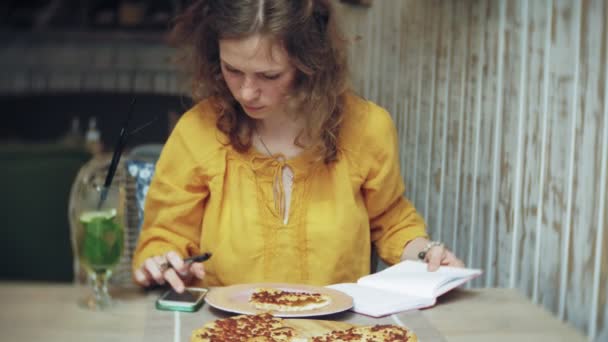 Egy fiatal nő iszik egy koktél, egy kávézó-bárban, és használja a telefon — Stock videók