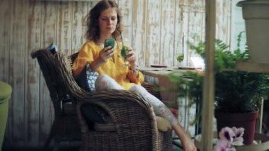 Genç kadın bir kafe barda bir kokteyl içer