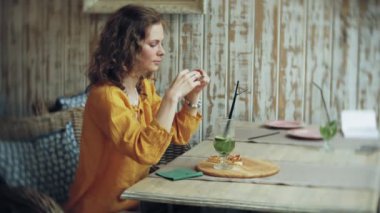 Genç kadın bir kafe barda bir smartphone cep telefonu ile bir pasta lazım