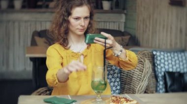 Genç kadın bir kafe barda bir smartphone cep telefonu ile bir pasta lazım