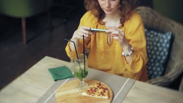 Junge Frau nimmt Kuchen in Café-Bar mit dem Smartphone — Stockvideo