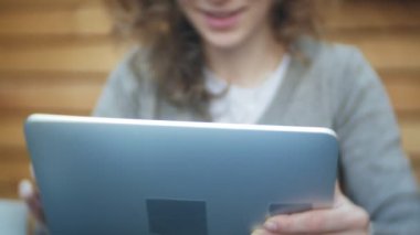 Genç kadın bir tablet ve telefon kullanıyorsa, bir kafe barda çay içer
