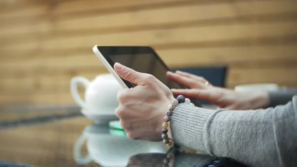 Fiatal nő használja a tablet és telefon, italok tea egy kávézó-bár — Stock videók